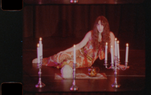A person laying down with candles around them, shot on 16mm. 